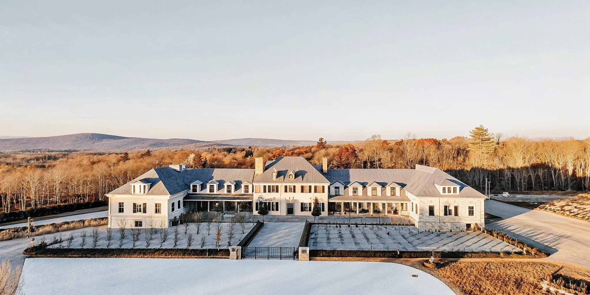 Aerial view of a French Chateau-inspired private estate on lush grounds in autumn, New England
