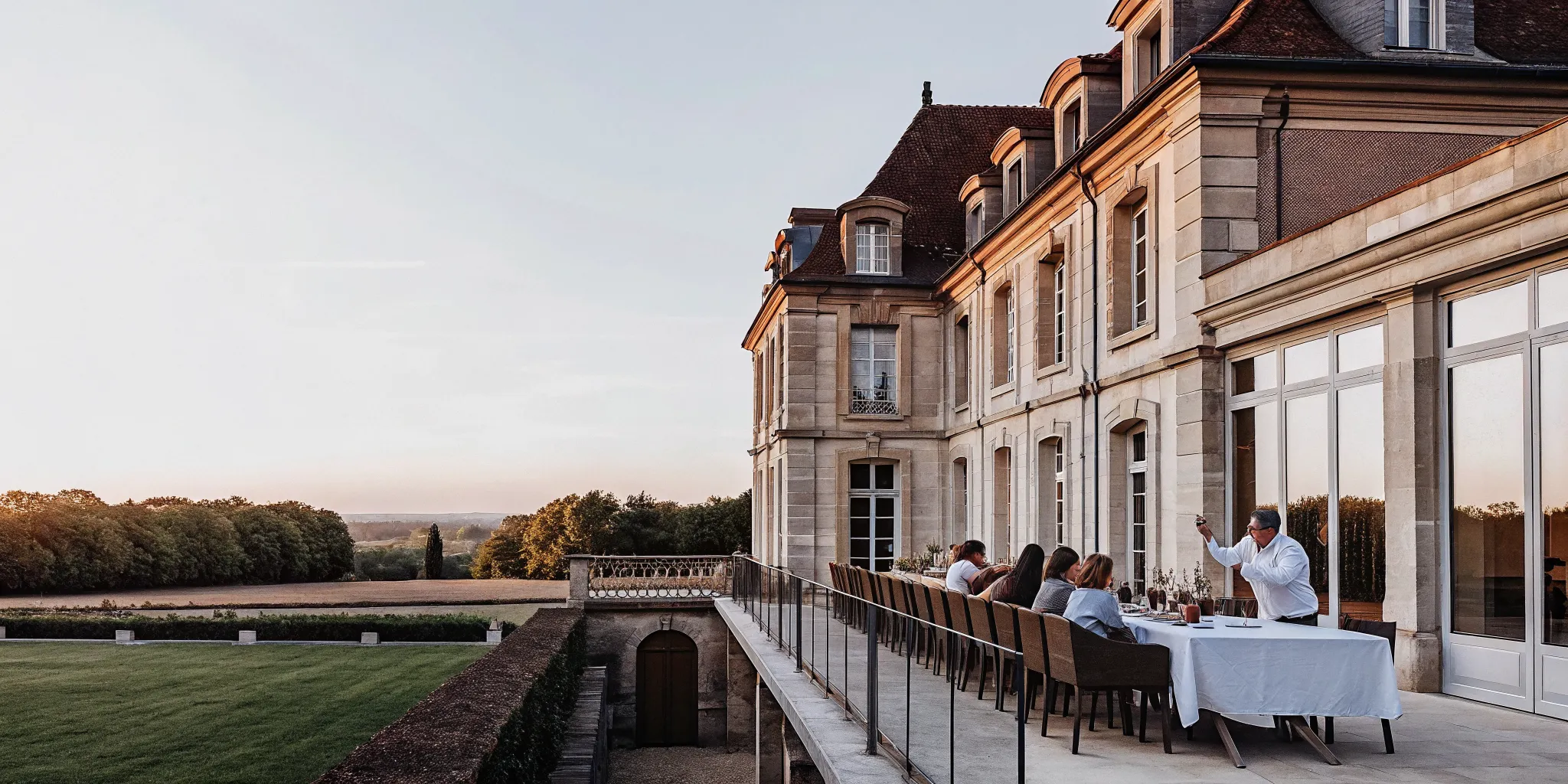 Luxurious French chateau estate with outdoor terrace and manicured lawn, ideal for multi-generational family gatherings
